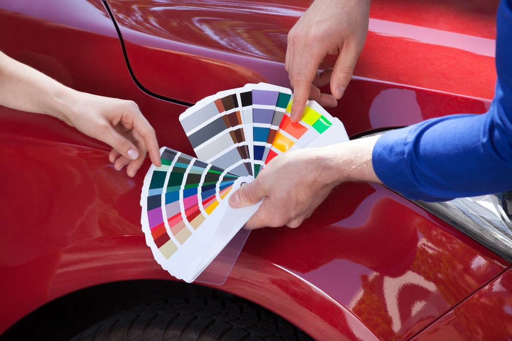 Car colour samples held against car