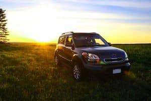 Car Loans Banner - SUV parked in a field at sunset