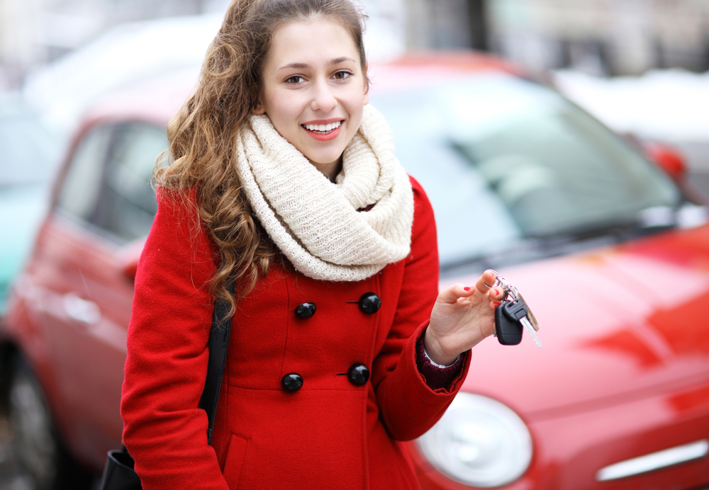 Woman with car keys in front of car