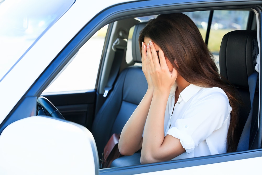Upset woman in car regretting purchase