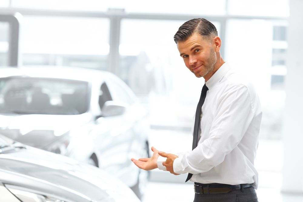 Car dealer selling cars in showroom