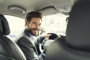 Man in suit driving car for work