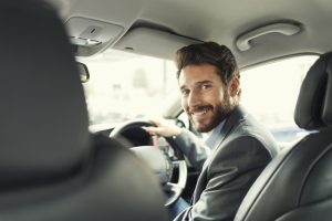Man in suit driving car for work