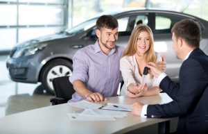Man and woman buying car at dealership