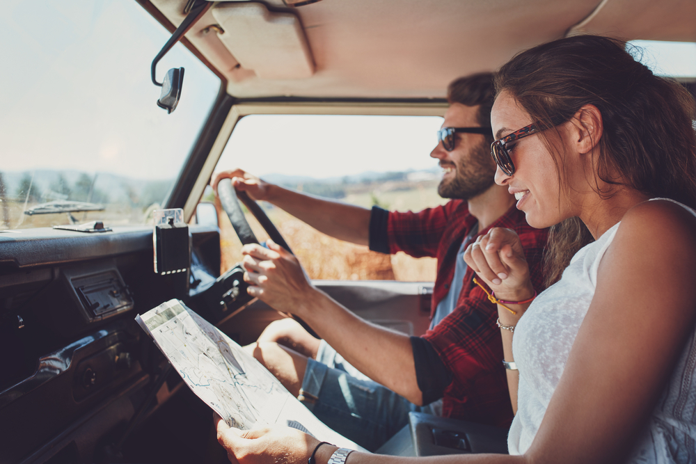 Couple using map in car on road trip