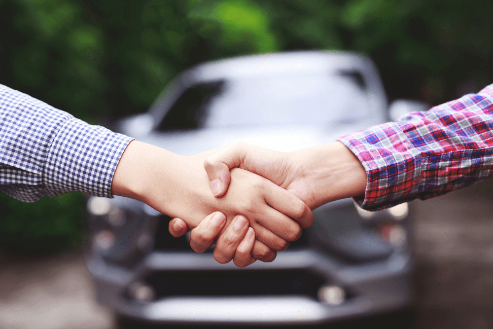 Car Loans Banner - Handshake in front of a car after a private used vehicle sale