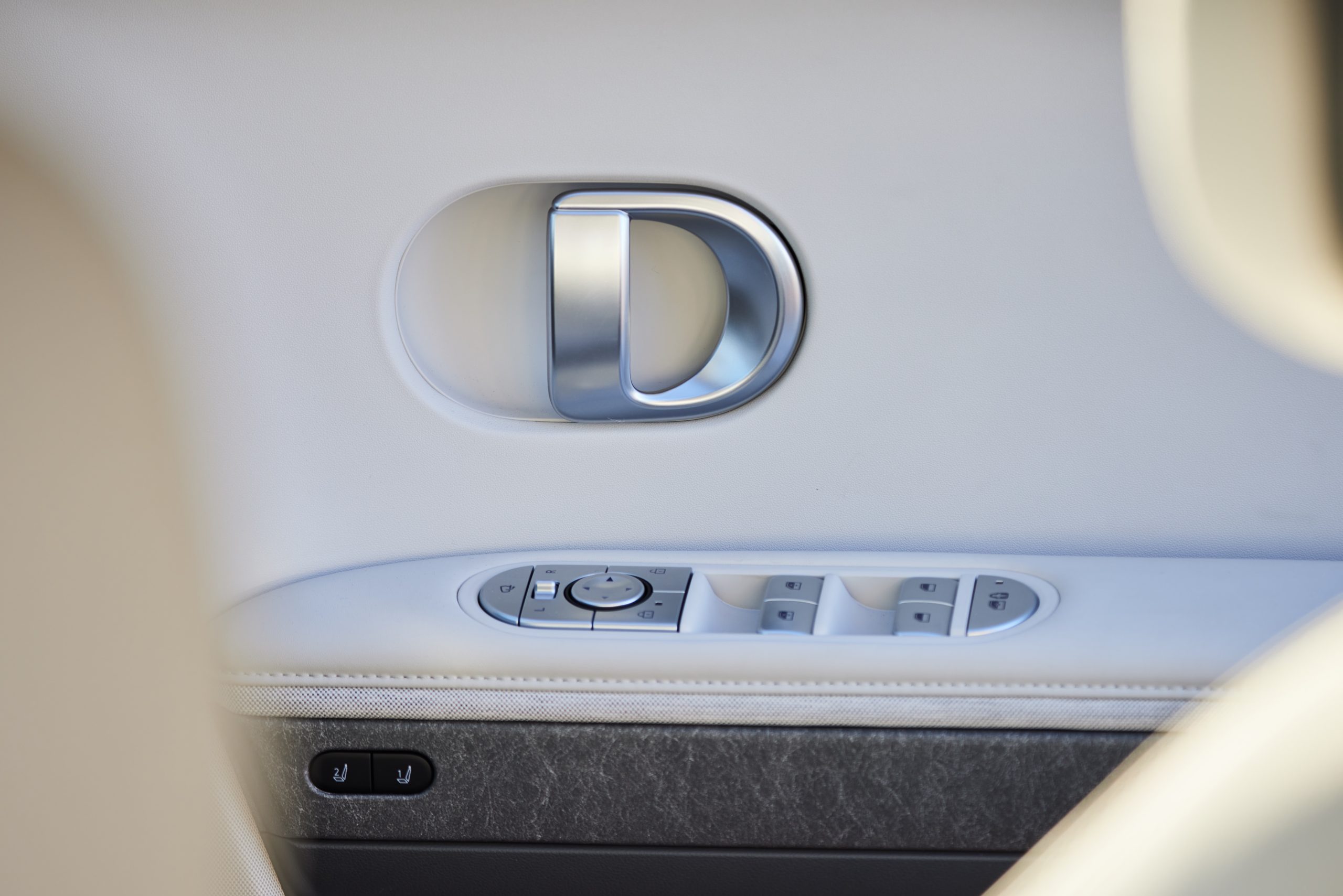 Hyundai IONIQ 5 close up of interior driver side door handle and arm rest controls