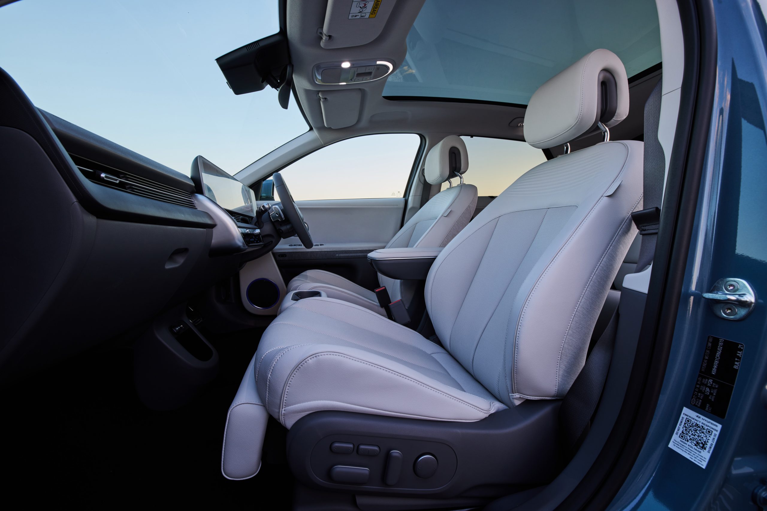 Hyundai IONIQ 5 inside cabin view looking across passenger and driver's white leather seats from passenger door