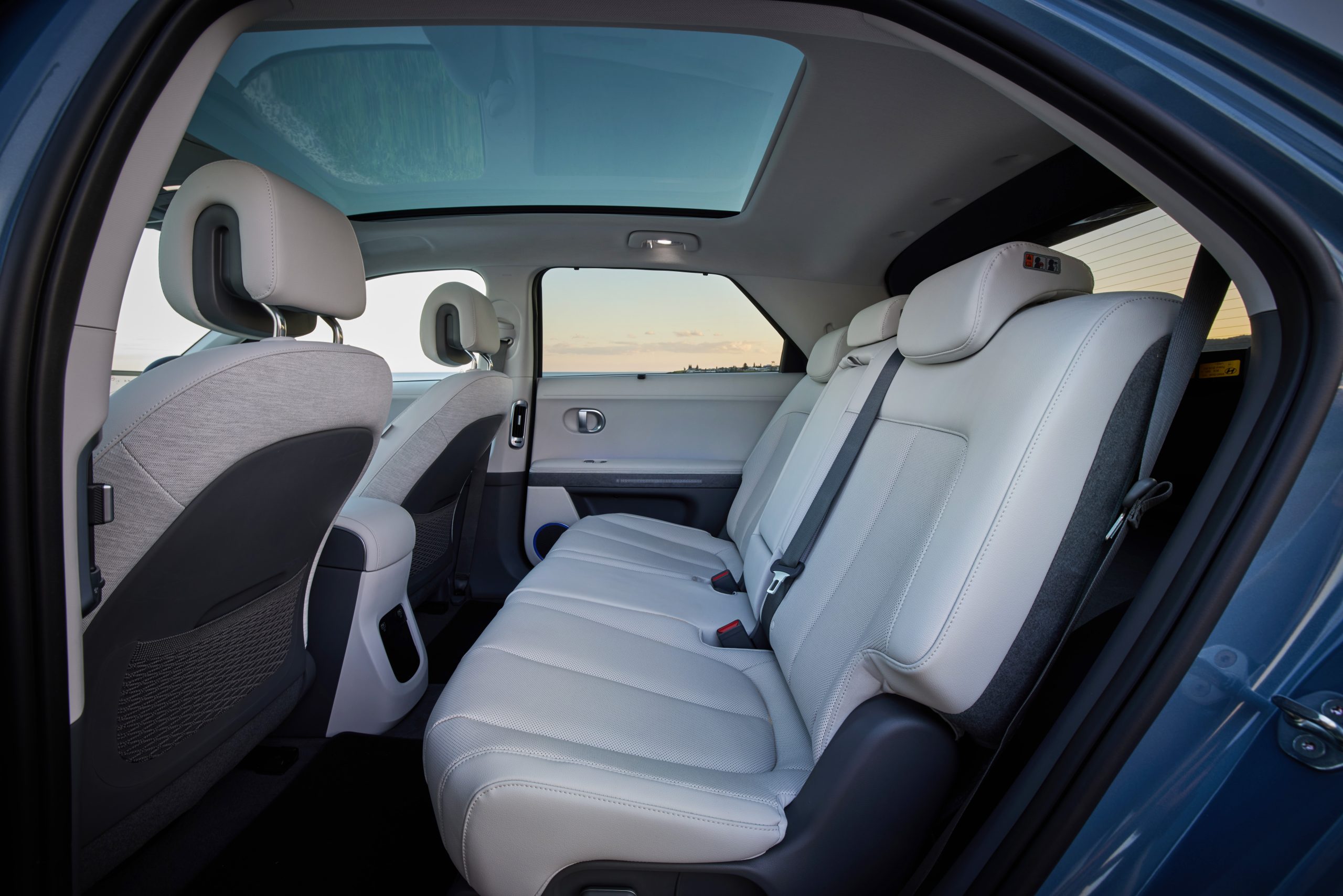 Hyundai IONIQ 5 inside cabin view looking across rear passenger and driver's white leather seats from door