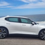 Snow coloured Polestar 2 dual motor EV with performance pack side view by the sea