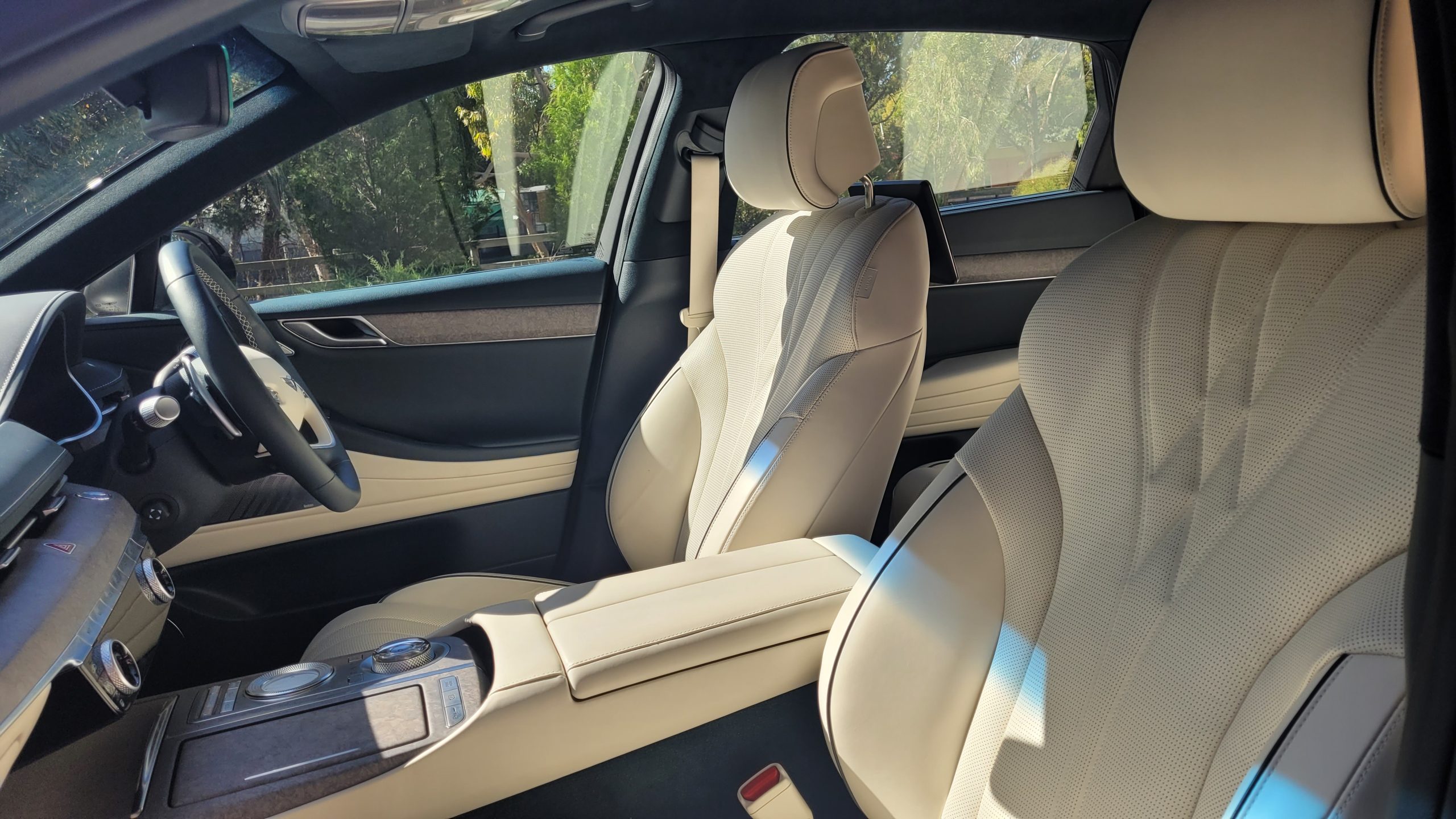Makalu Matte Gray Genesis G80 electric vehicle cream coloured front seats and centre console from left passenger door