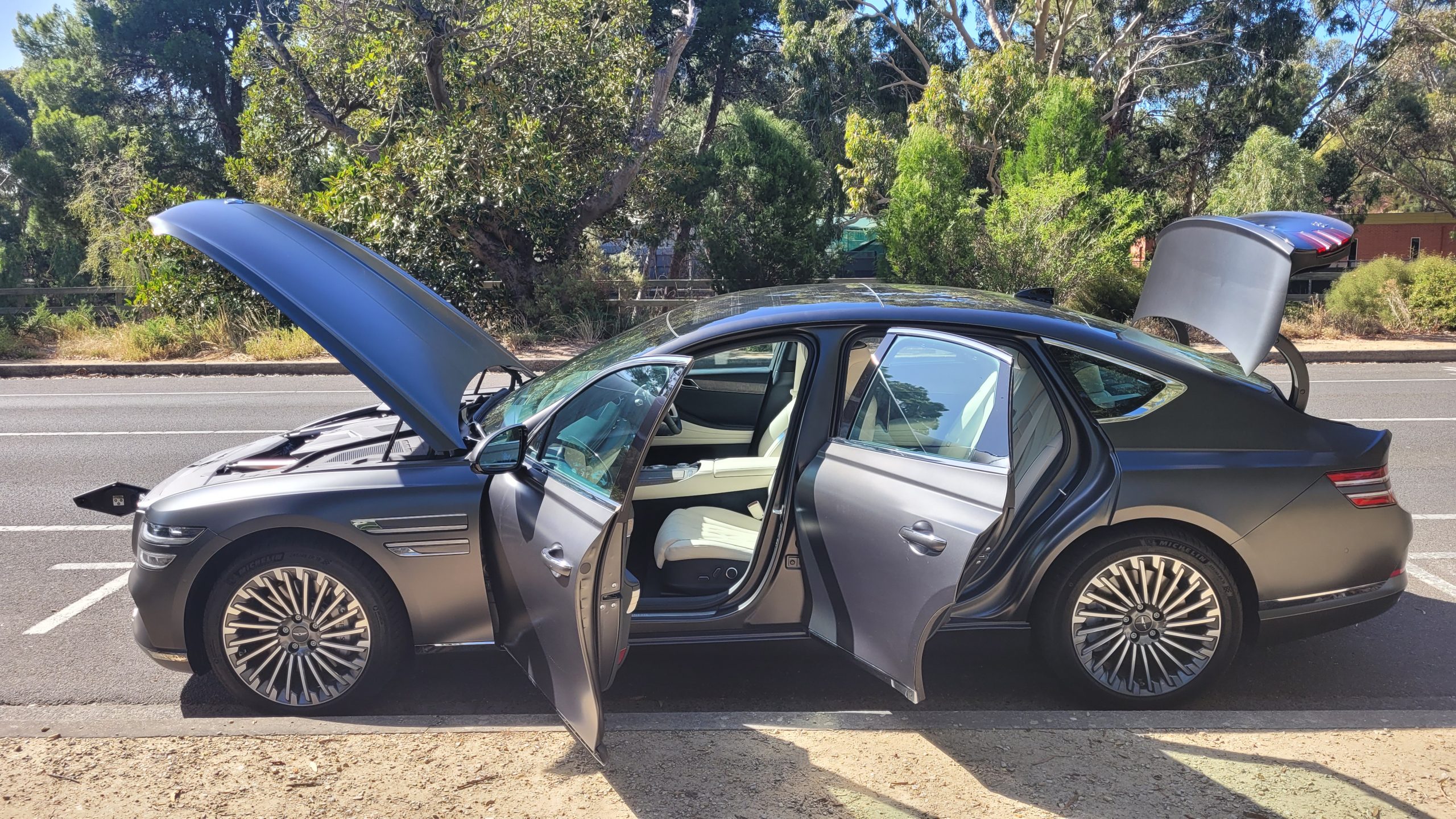 Genesis G80 electric vehicle left-hand side profile view with hood, doorsa and trunk open