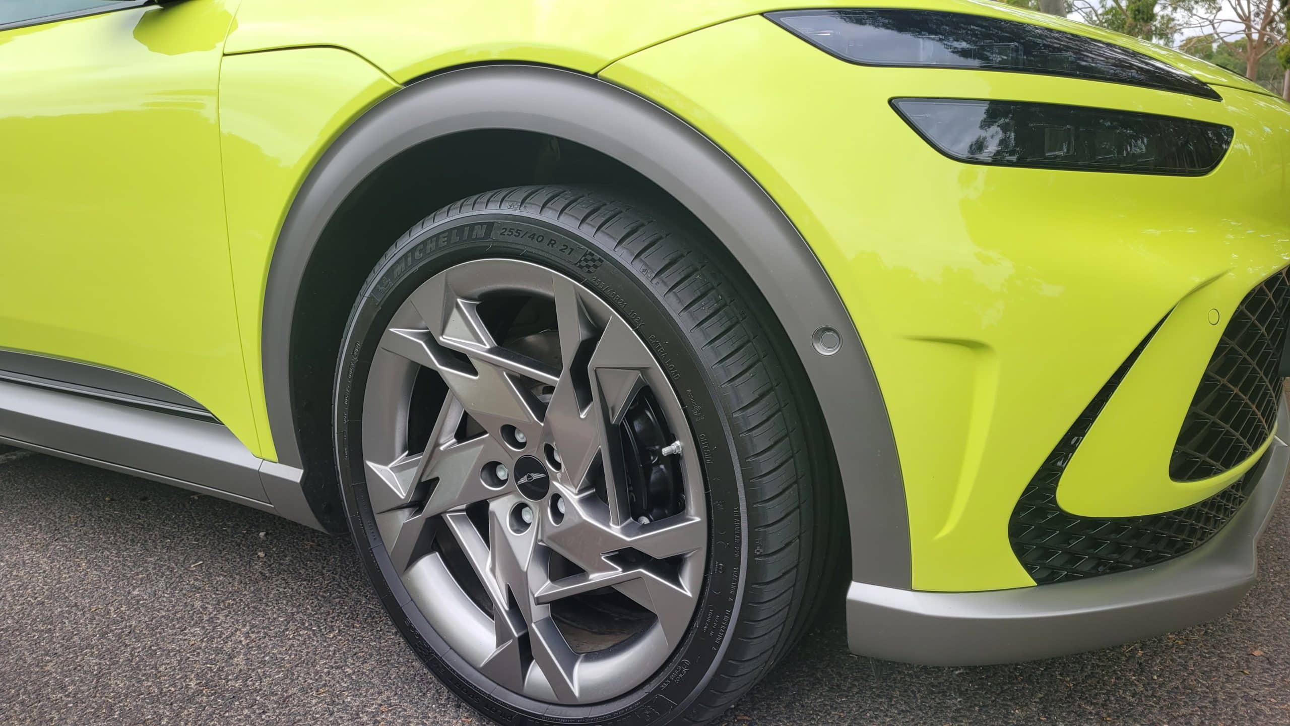 Genesis GV60 lime green view of front right-hand mag wheel.