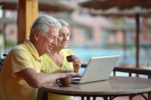 Energy Banner - Older couple comparing the best gas plans on their laptop with a pool in the background