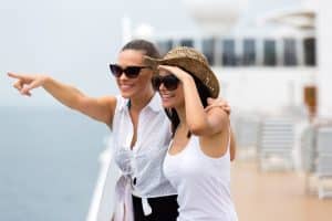 Travel Insurance Banner - Two women look out over the ocean while on a cruise.