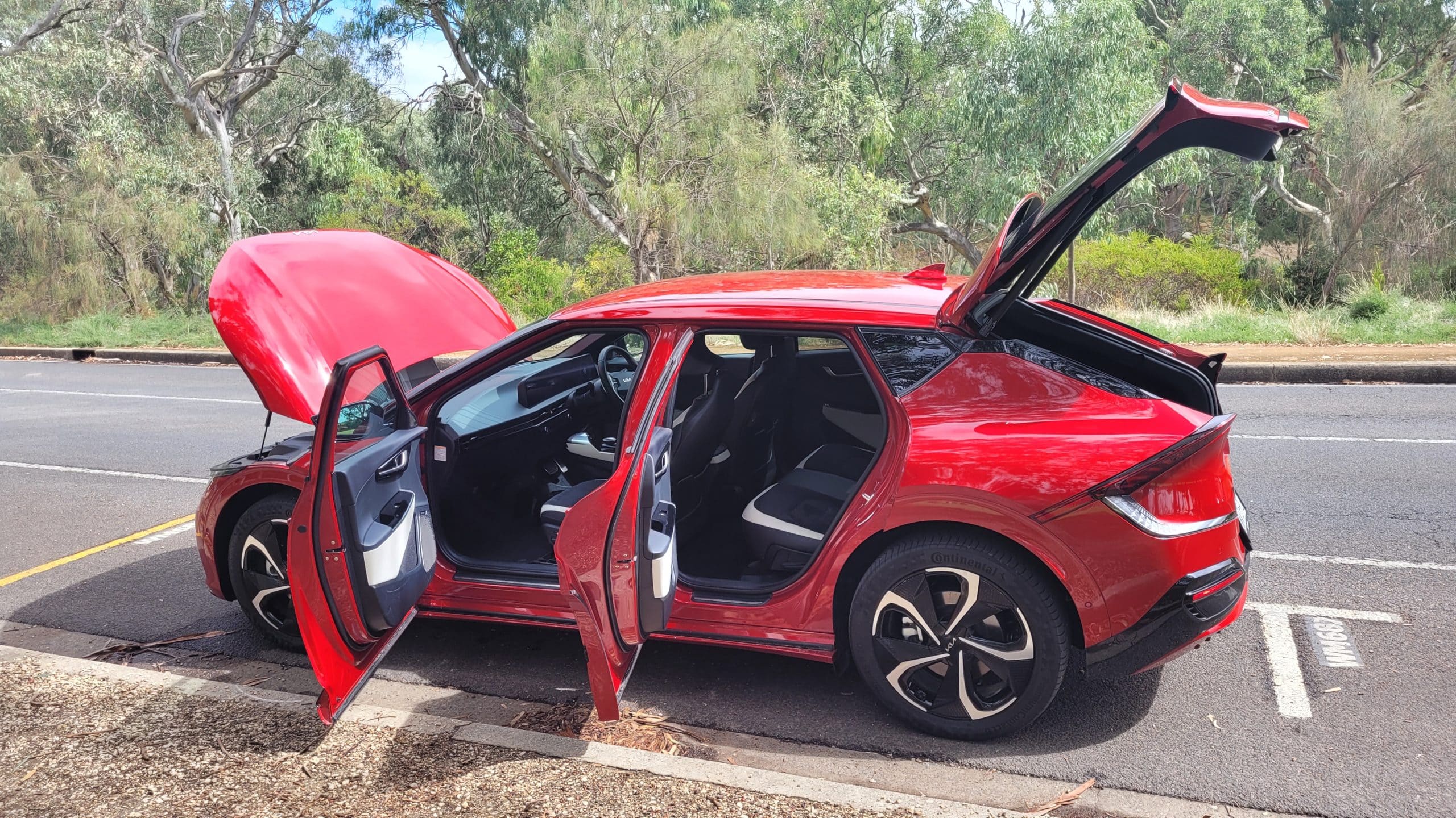 Red Kia EV6 GT-Line exterior rear side veiw with doors open