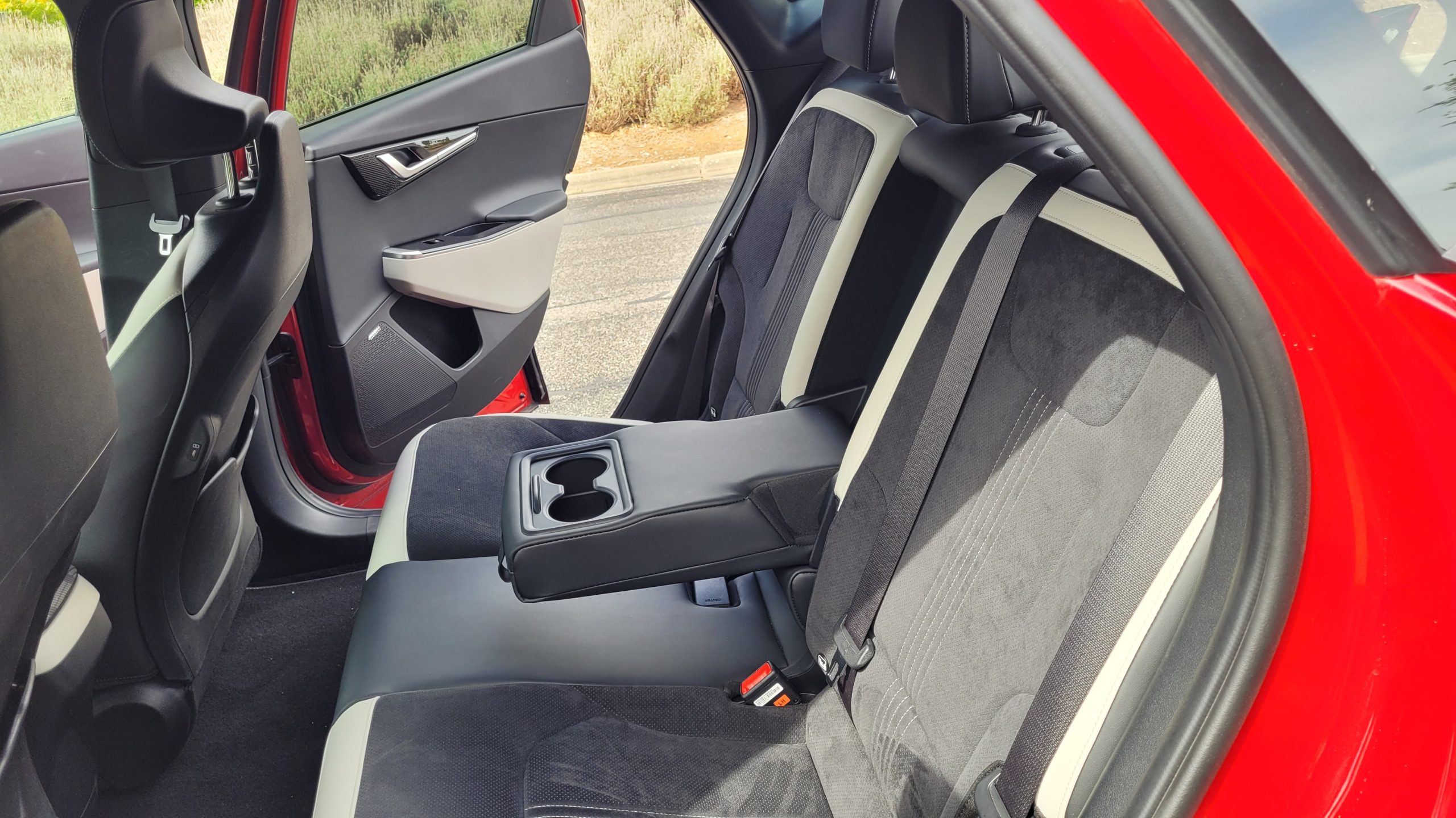 Red Kia EV6 GT-Line rear seat interior view with middle arm rest and cup holders in down position