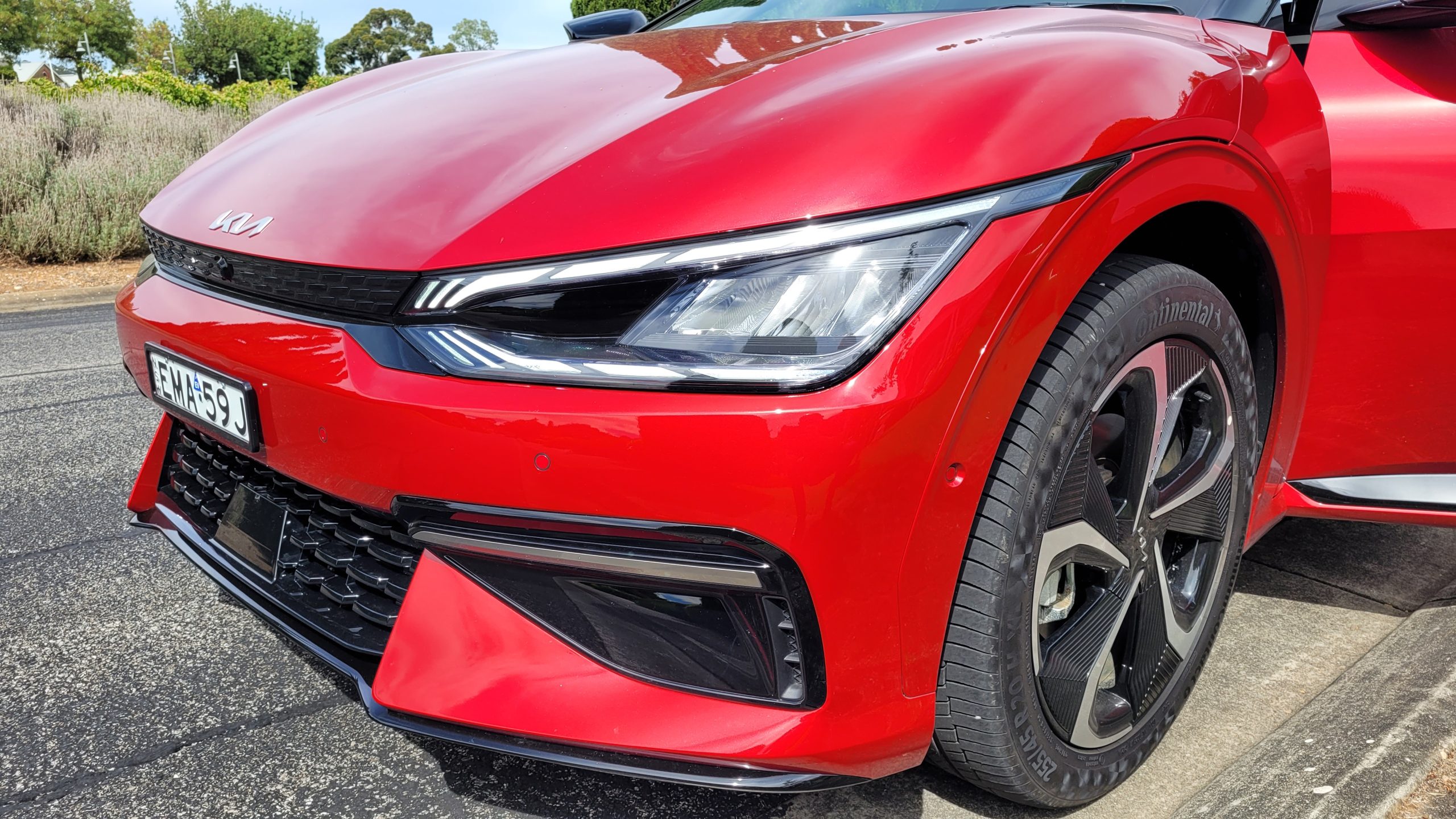 Red Kia EV6 GT-Line close up of front headlights, bumper and wheel
