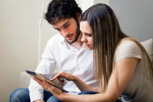 Car Insurance Banner - Young couple making a car insurance claim on their tablet