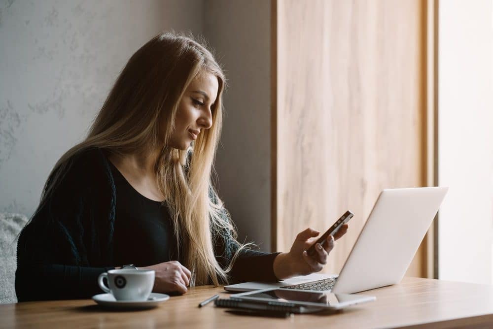 Car Insurance Banner - Woman looking at her phone waiting for her car insurance claim