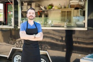 Business Loans Banner - Food truck business owner standing in front of his food truck