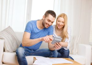 Life Insurance Banner - Young couple doing their taxes using a calculator