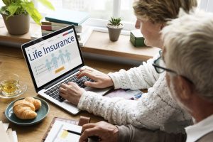 Life Insurance Banner - Elderly couple looking at life insurance policies on a laptop