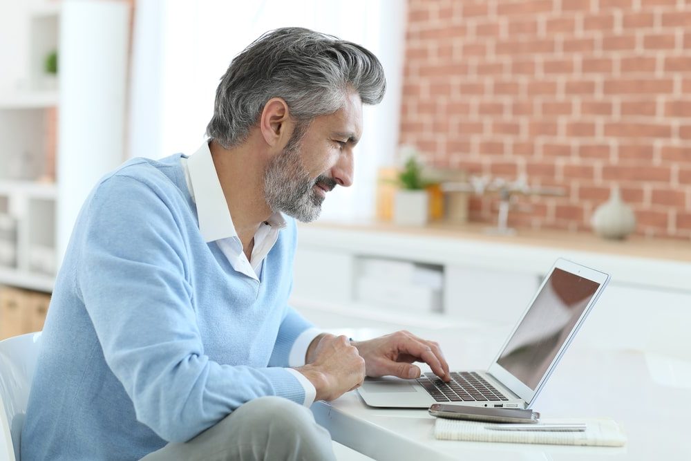 Personal Loans Banner - Middle-aged man looking at his personal loan eligibility on a laptop