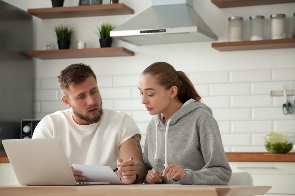 Personal Loans Banner - Young couple looking at their finances at a kitchen table