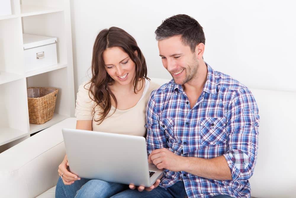 Car Insurance Banner - Couple looking at their laptop after purchasing car insurance