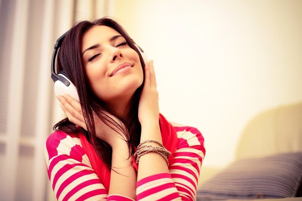 Personal Loans Banner - Young woman with her eyes closed listening to music through her headphones