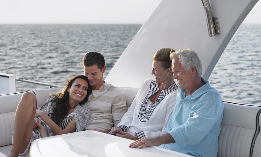 Life Insurance Banner - A young and older couple relaxing on a boat in the ocean