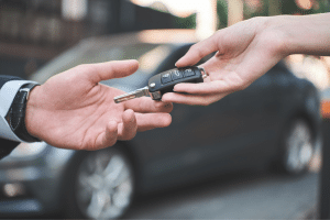 Car key being handed to new owner