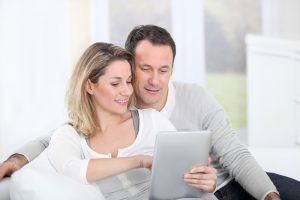 Small Loans Banner - Couple learning about what cash loans are on their tablet