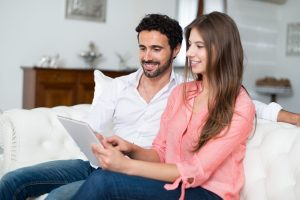 Small Loans Banner - Young couple looking for a fast cash loan on their tablet