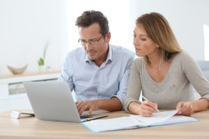 Bank Accounts Banner - Couple comparing joint bank accounts on their laptop and taking notes