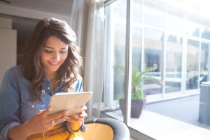 Internet Banner - Young woman sitting at a table on her tablet