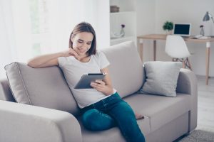 Internet Banner - Young woman sitting on the couch looking at a tablet