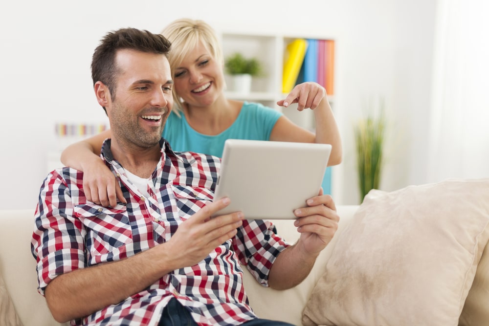 Internet Banner - A man and woman sitting on a couch looking at a tablet