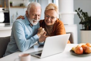 Internet Banner - An older couple smiling at a laptop at home