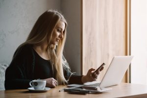 Internet Banner - A woman sitting at a table with a laptop and mobile phone