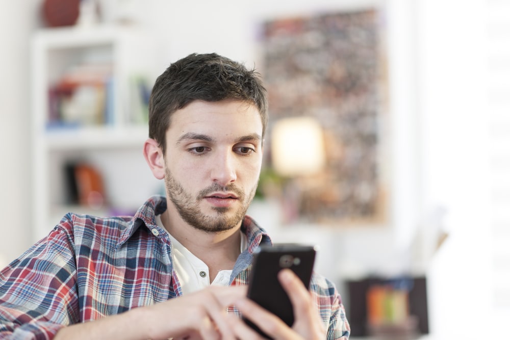 Internet Banner - Worried young man looking at his phone