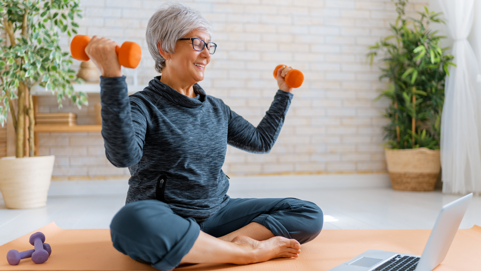 Elderly lady happily exercising with dumbells on her floor