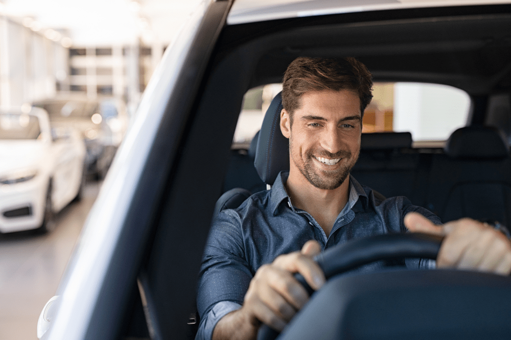 Car Loans Banner - Smiling man driving his car